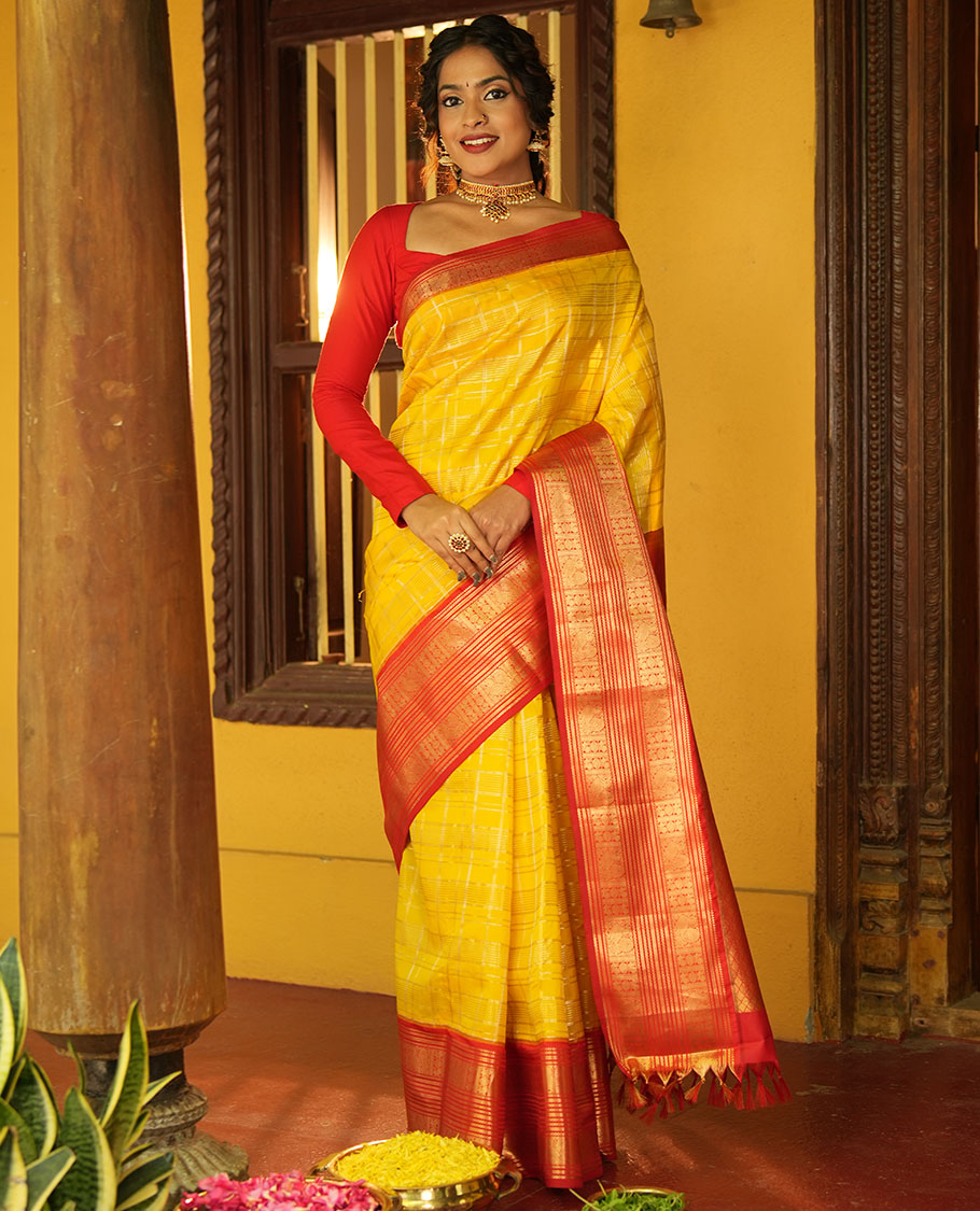Lemon Yellow and Red Vasundhara Lite Silk Saree, Richly Detailed with Zari Checked Design On Its Body, Complemented by Contrast Varisai Pettu Border of Mayil Chakram Designs, Grand Jaal Pallu, and Paired with a Contrast Blouse