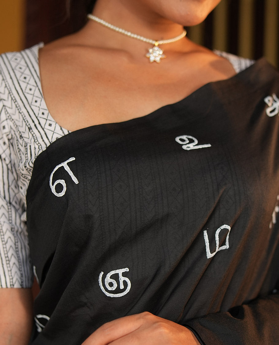 Borderless Black South Cotton Saree, Adorned with Tamil Letters Printed on Its Body, a Self-Pallu, and Comes with a Matching Blouse, and a Contrast Printed Blouse