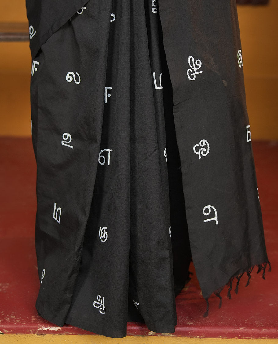 Borderless Black South Cotton Saree, Adorned with Tamil Letters Printed on Its Body, a Self-Pallu, and Comes with a Matching Blouse, and a Contrast Printed Blouse