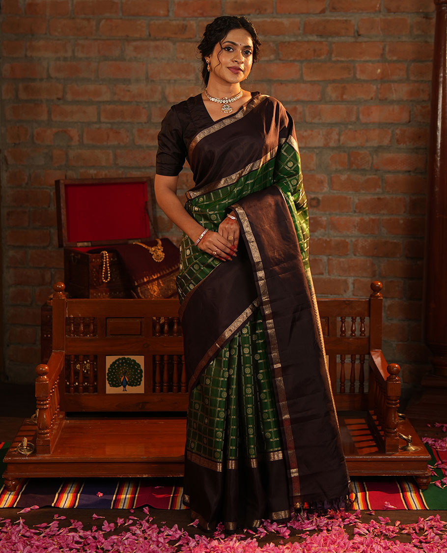 Green Vasundhara Silk Saree Richly Detailed with Chakram Butta Enclosed Checks, Highlighted with a Contrast Rettai Pettu of Rekku, Muthu, and Dhavana Kodi Designs, Zari-Rich Pallu of Jaal Designs, and Paired with a Contrast Blouse