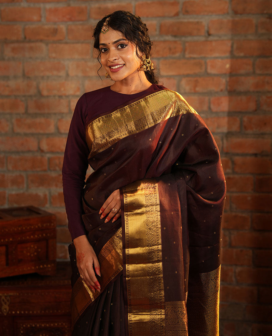 Brown Vasundhara Silk Saree Beautified with Zari Buttas All Over Its Body, Gleamed Up with a Zari Border of Thilakam Mokku, Kathir, Rudraksham, and Arumbu Manga Designs, Majestically Detailed Pallu of Jaal Designs, and Comes with a Matching Blouse