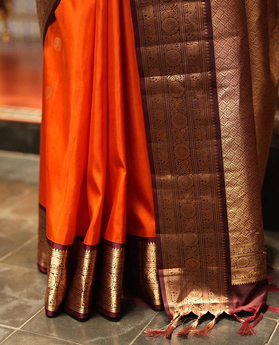 Rust Orange Vasundhara Silk Saree, Embellished with Mayil and Yaanai Buttas Across Its Body, Complemented by a Contrast Korvai Border of Rekku, Banaras, Yaanai, and Chakram Designs, Gleaming Jaal Pallu, and Paired with a Contrast Blouse