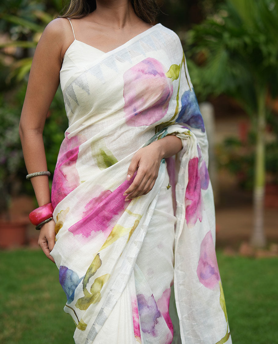 Cream-Base Linen Saree, Highlighted by Floral-Themed Paint Splashes, Hand-Brush Painted All Over Its Body, Sparsely Woven Temple Border, and Paired with a Matching Blouse