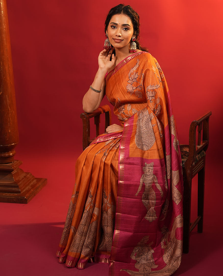 Orange Semi-Tussar Silk Saree, Artfully Detailed with Kalamkari-Style Human Motifs Printed on Its Body, Complemented by a Contrast Temple Zari Border, Creatively Kalamkari Printed Pallu, and Paired with a Contrast Blouse