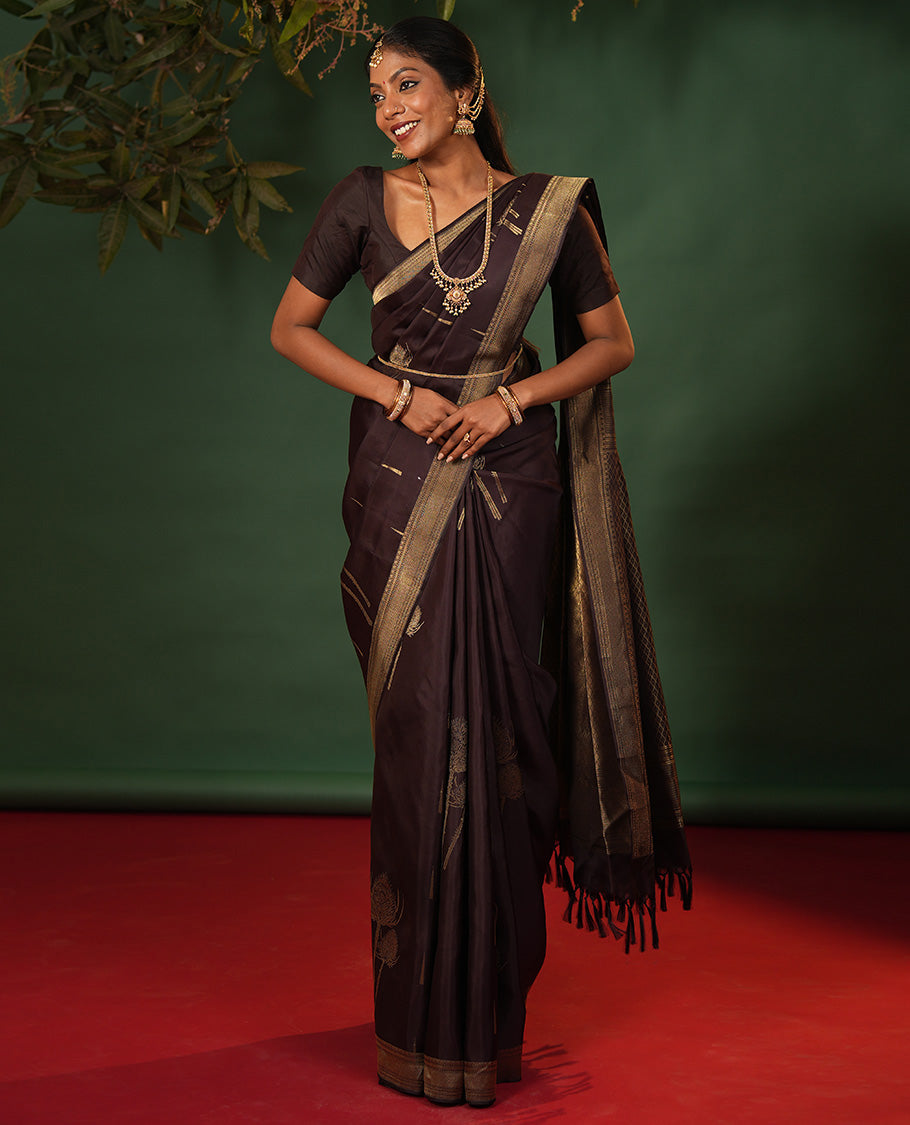 Coffee Brown Vasundhara Silk Saree Decked Up with Thazampoo Rekku Buttas and Vel Buttas, Highlighted with a Zari Border of Manga, Muthu, Kathir, Neli, and Vanki Designs, Subtly Sparkled Pallu of Jaal Design, and Paired with a Matching Blouse