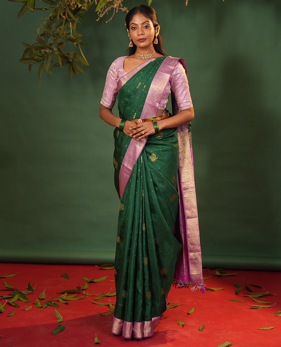 Green Vasundhara Silk Saree Embellished with Yaanai and Mayil Buttas, Complemented by a Contrast Border of Muthu, Kathir, Mayil, and Yaanai Designs, Pallu Embellished with Diagonal Stripes, and Paired with a Contrast Blouse