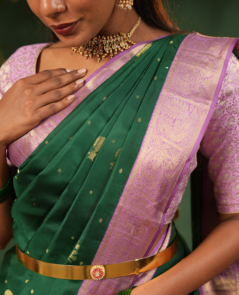 Green Vasundhara Silk Saree Embellished with Yaanai and Mayil Buttas, Complemented by a Contrast Border of Muthu, Kathir, Mayil, and Yaanai Designs, Pallu Embellished with Diagonal Stripes, and Paired with a Contrast Blouse