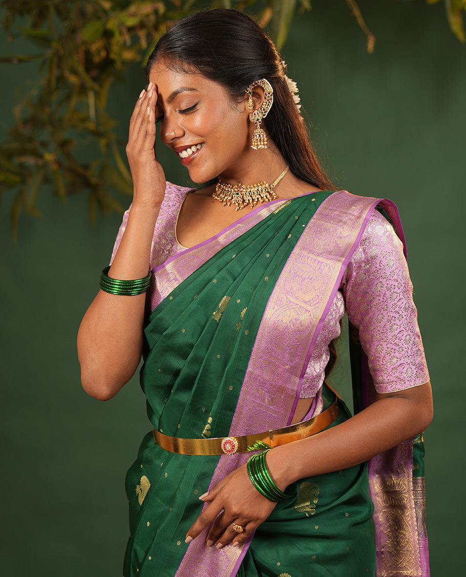 Green Vasundhara Silk Saree Embellished with Yaanai and Mayil Buttas, Complemented by a Contrast Border of Muthu, Kathir, Mayil, and Yaanai Designs, Pallu Embellished with Diagonal Stripes, and Paired with a Contrast Blouse
