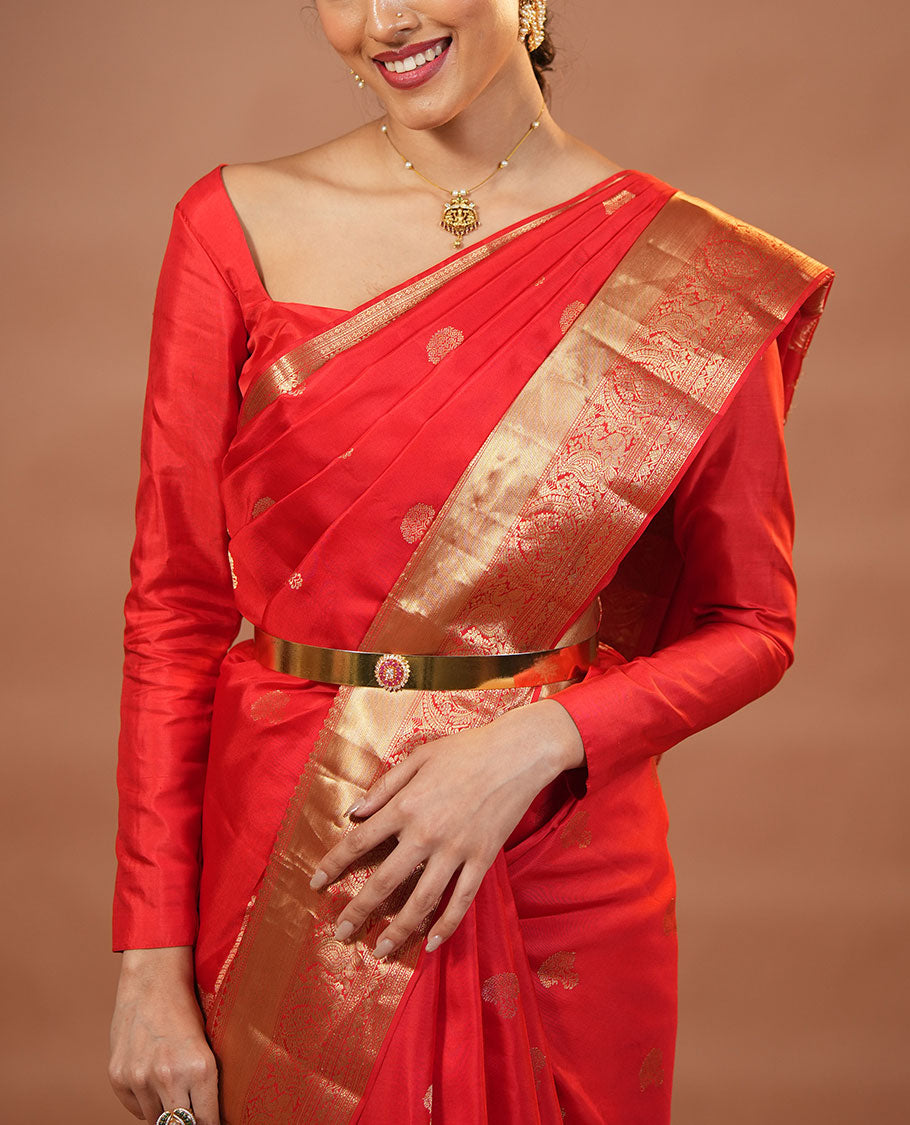 Red Vasundhara Silk Saree Traditionally Decked Up with Zari Buttas and Mamallapuram Temple Motifs, Highlighted by a Zari Border of Salangi, Muthu, Banaras, Mayil, and Lavangam Designs, Gracefully Embellished Pallu, and a Matching Blouse
