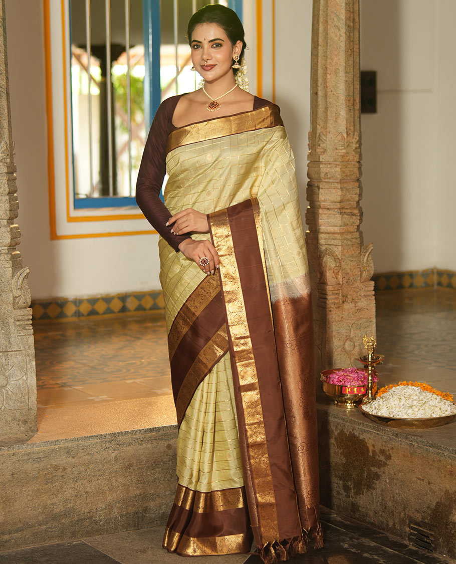 Pale Green Vasundhara Silk Saree, Enriched with Zari Buttas Enclosed Checks All Over Its Body, Complemented by a Contrast Rettai Pettu Border of Muthu, Banaras, and Iruthalai Pakshi Designs, a Grand Pallu, and Paired with a Contrast Blouse