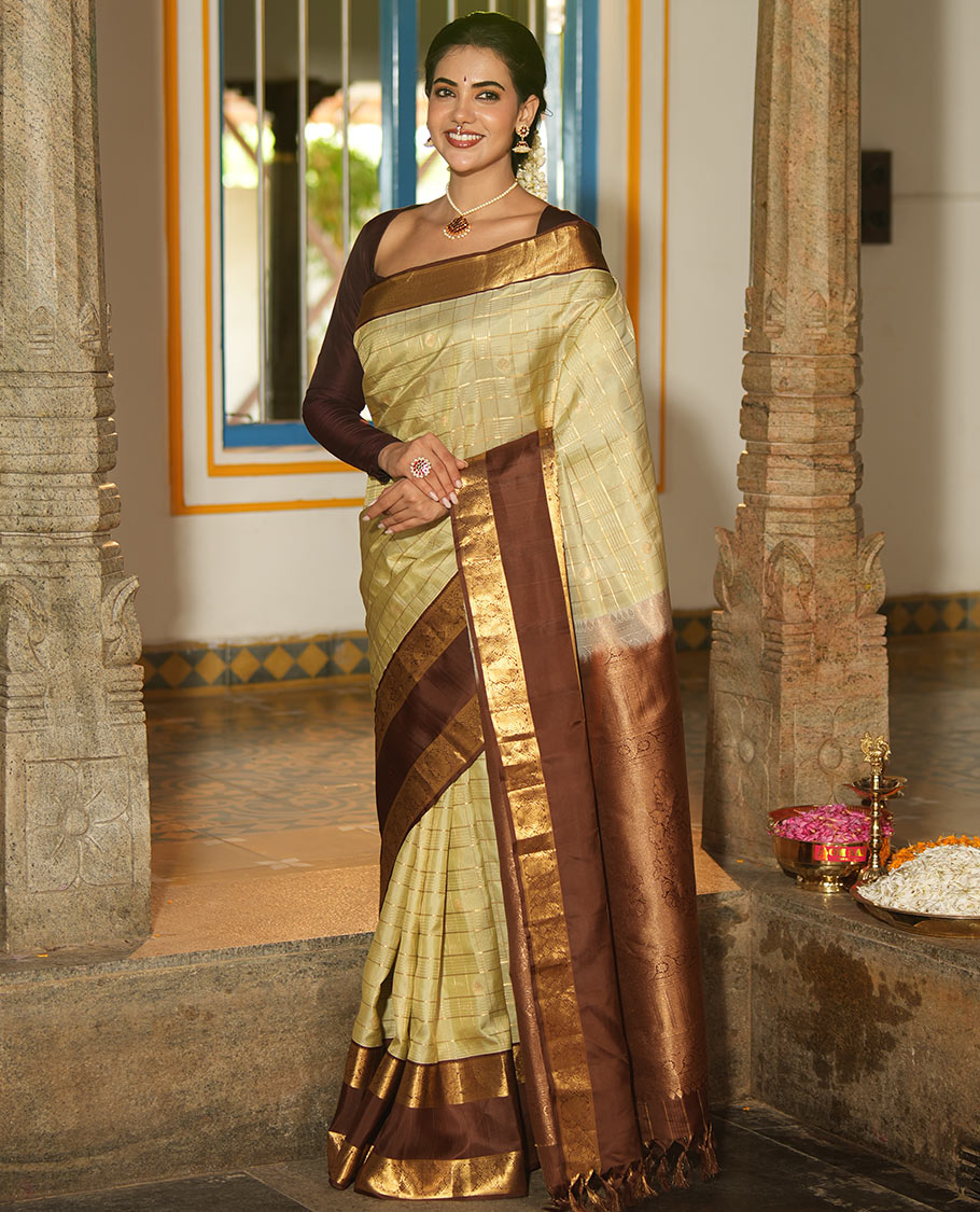 Pale Green Vasundhara Silk Saree, Enriched with Zari Buttas Enclosed Checks All Over Its Body, Complemented by a Contrast Rettai Pettu Border of Muthu, Banaras, and Iruthalai Pakshi Designs, a Grand Pallu, and Paired with a Contrast Blouse