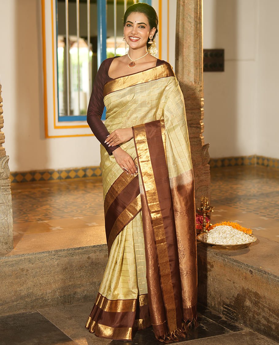 Pale Green Vasundhara Silk Saree, Enriched with Zari Buttas Enclosed Checks All Over Its Body, Complemented by a Contrast Rettai Pettu Border of Muthu, Banaras, and Iruthalai Pakshi Designs, a Grand Pallu, and Paired with a Contrast Blouse