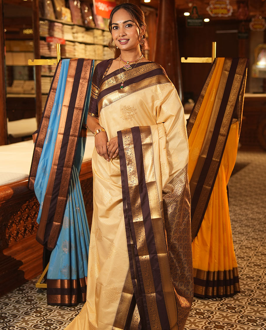 Sandal Budget Silk Saree, Embellished with Zari Stripes and Kolam Buttas All Over Its Body, Complemented by a Contrast Traditional Zari Design Rettai Pettu Border, Grand Scallop Design Pallu, and Paired with a Contrast Blouse