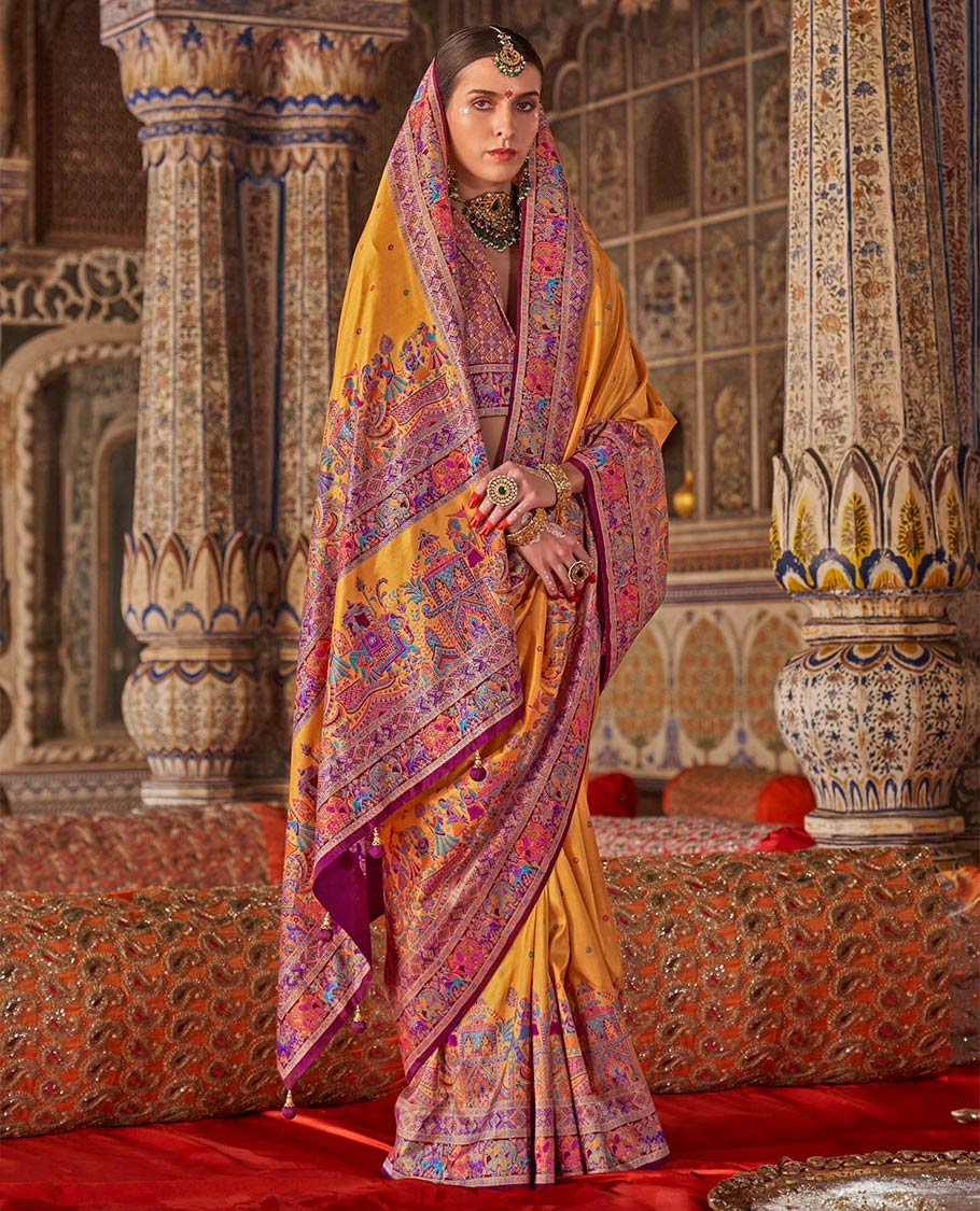 Yellow meena buttas designer catalog saree, contrast meenakari border of human and elephant motifs, and wedding theme meenakari pallu
