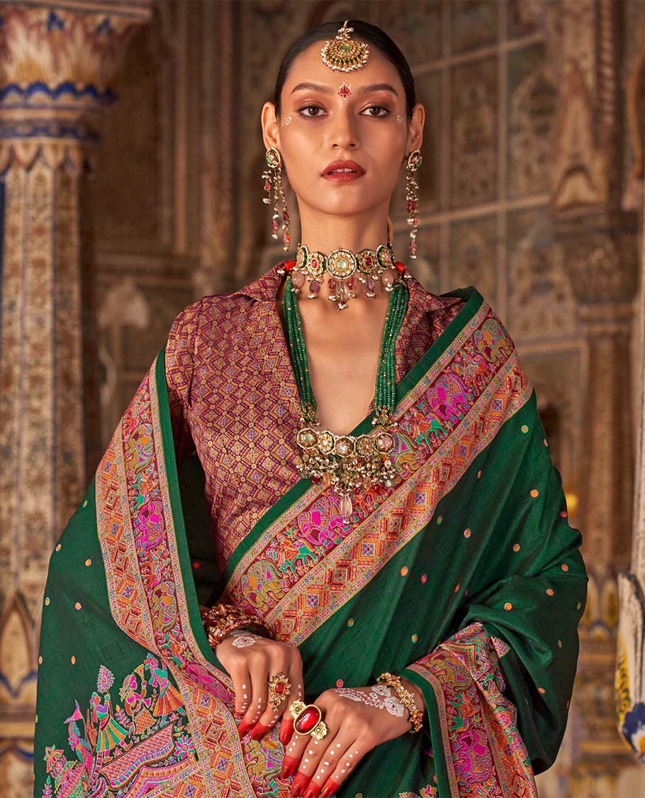 Bottle green meena buttas designer catalog saree, contrast meenakari border of human and elephant motifs, and wedding theme meenakari pallu