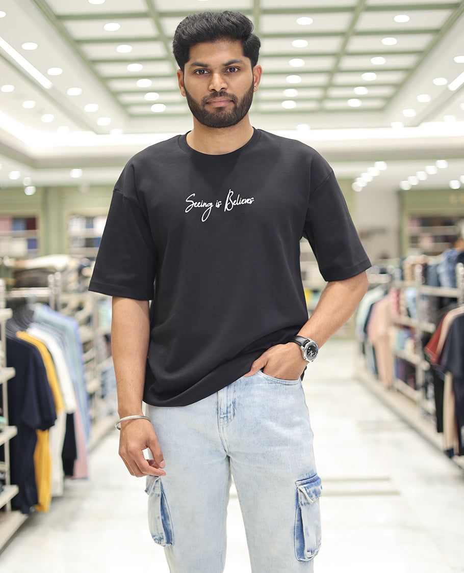 Black Glow in the Dark Cotton-Blended T-Shirt, Bedecked with Colorful Cartoon Motifs Print, Comes with a Crew Neck, Half-Sleeves, Oversized Fit, and Long Length