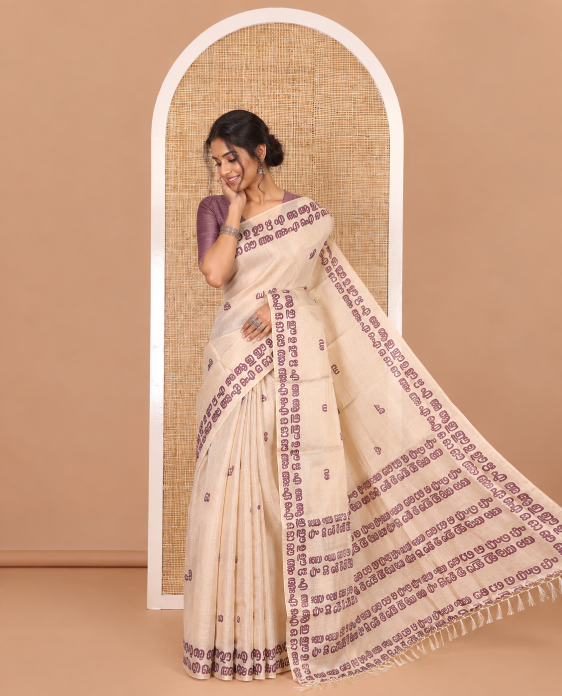 Cream-magenta Malayalam letter printed tissue saree, self-border and pallu steeped with Malayalam letter motifs, and a contrast plain blouse
