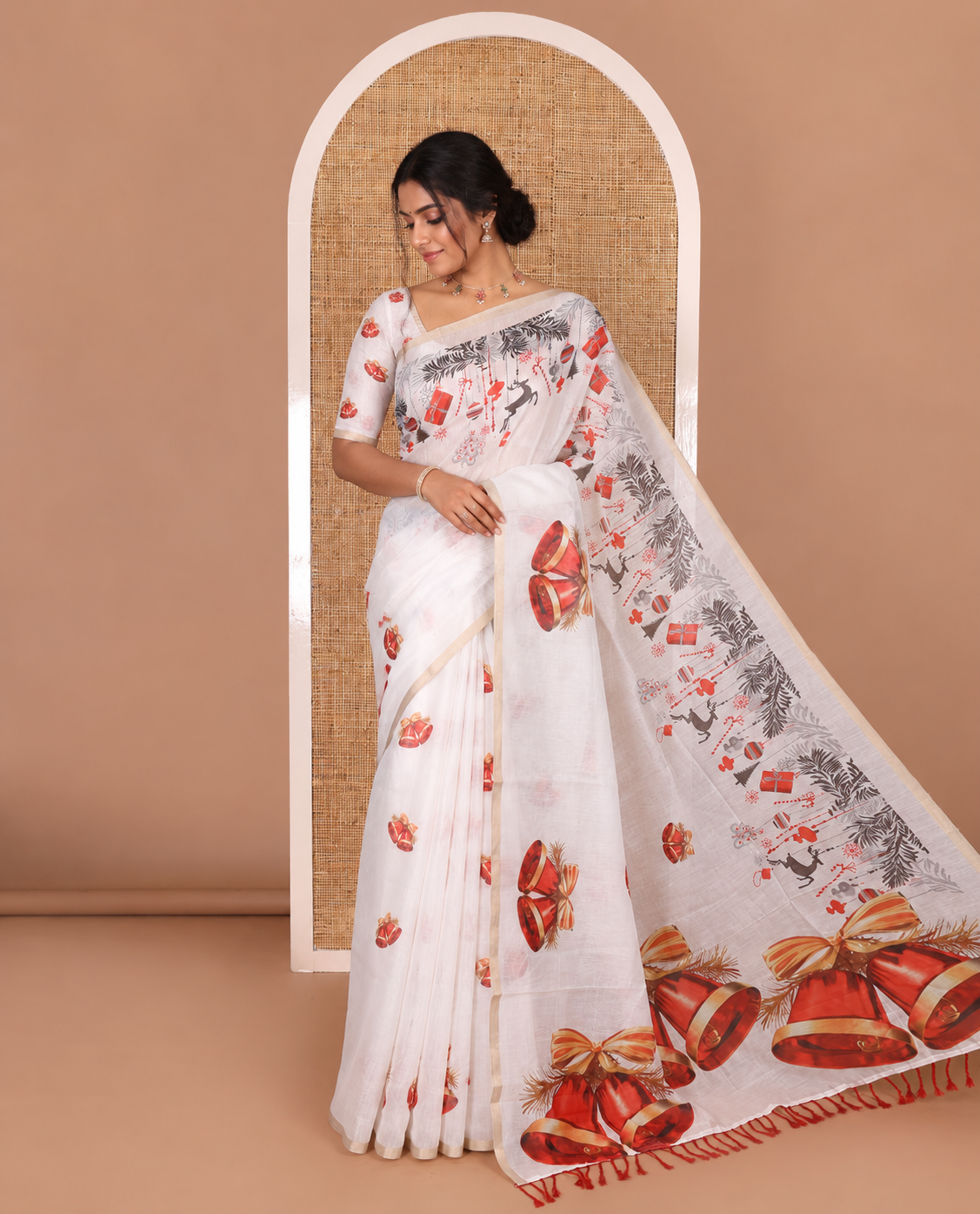 White Christmas-theme digital printed Chanderi cotton saree features bell motifs, piping zari border, big bell printed pallu, and blouse of tiny bell motifs print