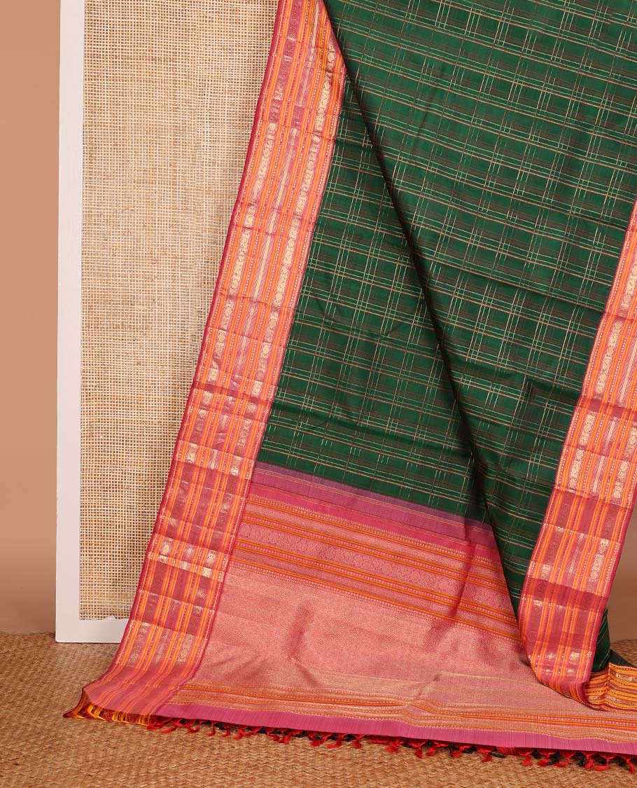 Green checked pure silk saree, contrast border of rekku, plus buttas, muthu, mayil kann, and mayil chakram designs, and zari-rich jaal pallu