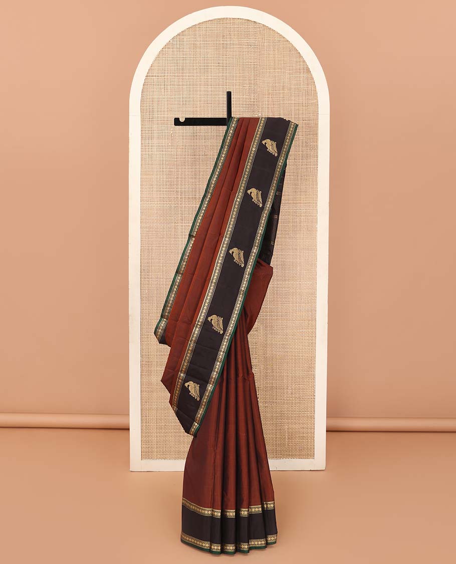 Rust plain Kanchipuram silk saree, contrast border of rekku, muthu, rudraksham and mayil, and zari striped pallu