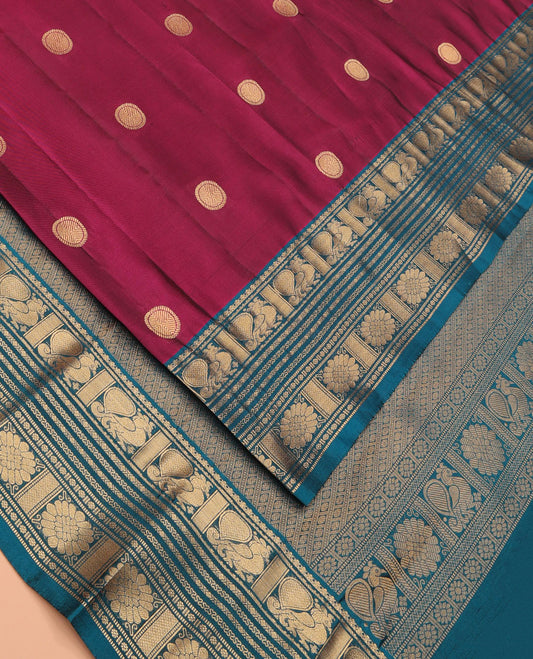 Magenta Vasundhara Lite Silk Mix Saree Featuring Rudraksham Buttas, Complemented by a Contrast Border of Mayil, Cross Neli, Kamalam, Mayil Kann, Muthu, and Chakram Designs, Zari Elevated Pallu, and Paired with a Contrast Zari-Bordered Blouse