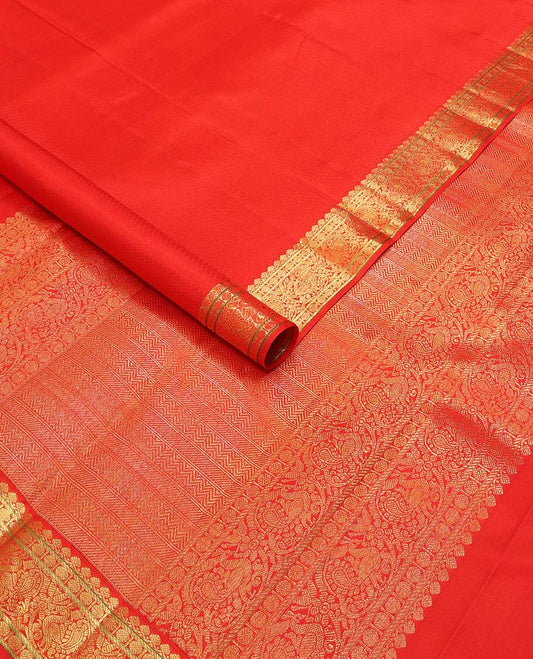 Red emnossed design silk saree with self border of thilakam mokku, paun, mayil design & floral pallu