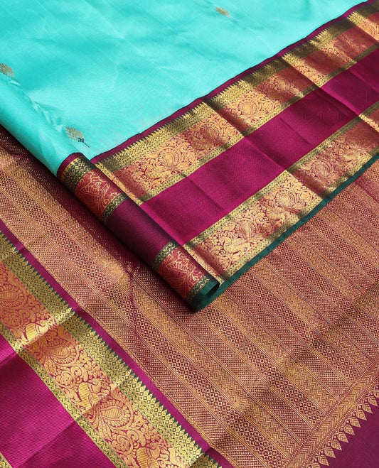 Blue meena buttas Kanchipuram silk saree, contrast korvai border of thilakam mokku, rettai neli, and mayil designs, and geometric patterned pallu