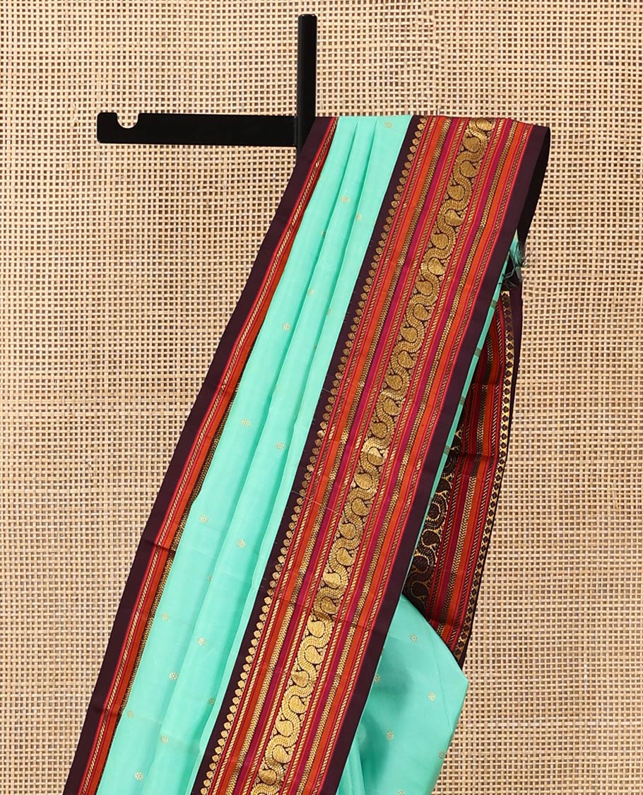 Turquoise zari buttas Kanchipuram silk saree, contrast korvai border of salangai, nuli nagam, kathir, and dhavanai manga kodi designs, and mayil kann woven pallu