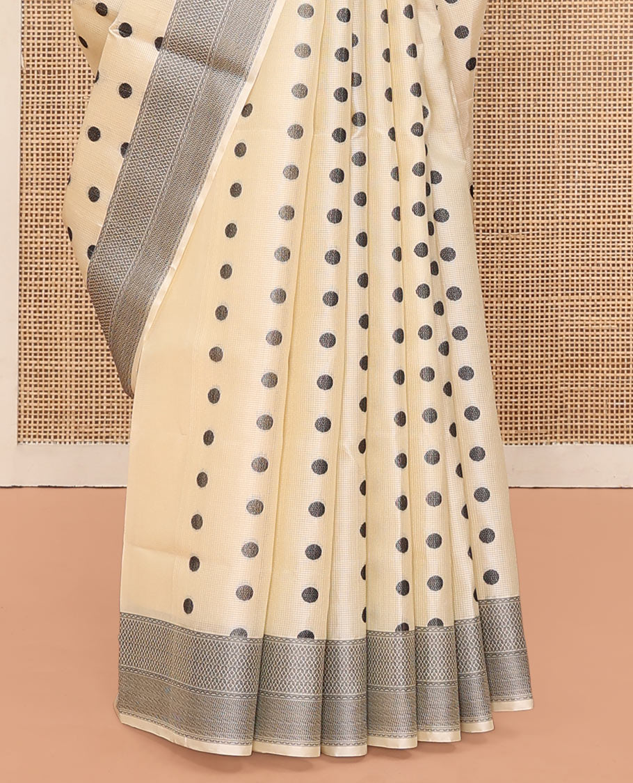 Cream Mayuri Soft Silk Saree, Accentuated with Polka Dot Buttas All Over Its Body, Sparsely Woven Geometric Patterned Border, Pallu Steeped with Floral Designs, and Paired with a Matching Blouse