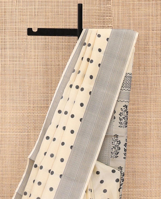 Cream Mayuri Soft Silk Saree, Accentuated with Polka Dot Buttas All Over Its Body, Sparsely Woven Geometric Patterned Border, Pallu Steeped with Floral Designs, and Paired with a Matching Blouse