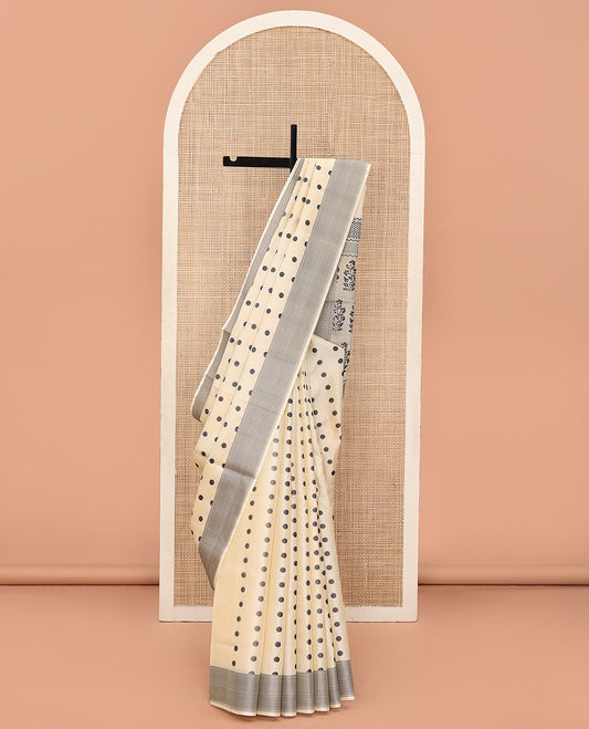 Cream Mayuri Soft Silk Saree, Accentuated with Polka Dot Buttas All Over Its Body, Sparsely Woven Geometric Patterned Border, Pallu Steeped with Floral Designs, and Paired with a Matching Blouse