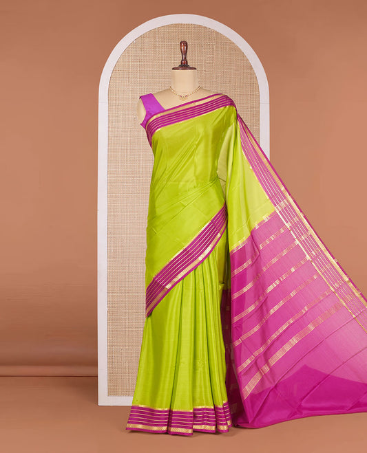 Parrot Green Plain Mysore Silk Saree, Highlighted by a Contrast Border Featuring Traditional Zari Designs, Pallu Steeped with Zari Stripes, and Paired with a Contrast Blouse