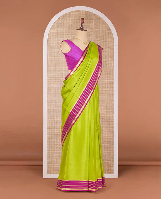 Parrot Green Plain Mysore Silk Saree, Highlighted by a Contrast Border Featuring Traditional Zari Designs, Pallu Steeped with Zari Stripes, and Paired with a Contrast Blouse
