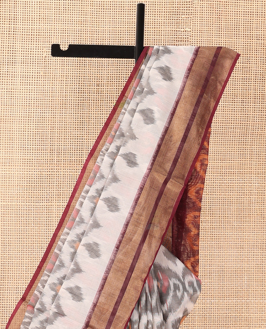 Pastel pink Pochampally Ikkat-style ogee patterned silk cotton saree, contrast zari border, and ikkat design pallu