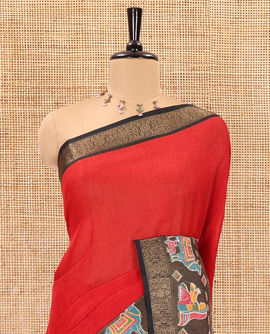 Red embossed moss chiffon saree, contrast zari and colorfully printed border and pallu of human figurines and Pichwai cows, and embossed blouse
