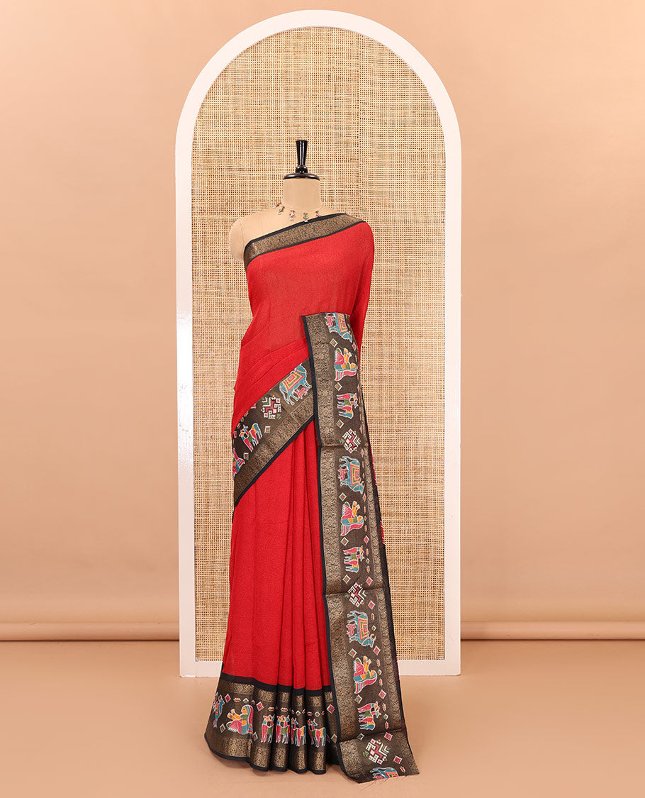 Red embossed moss chiffon saree, contrast zari and colorfully printed border and pallu of human figurines and Pichwai cows, and embossed blouse