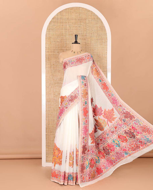 White kaleidoscopic floral motifs woven pashmina saree, kaleidoscopic floral border, Mughal style patterned pallu, and a colorful leaf jaal blouse