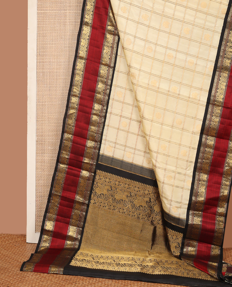 Cream iruthalai pakshi, and chakram buttas enclosed zari checked Kanchipuram silk saree, contrast rettai pettu border of salngai, muthu, and jadai nagam designs