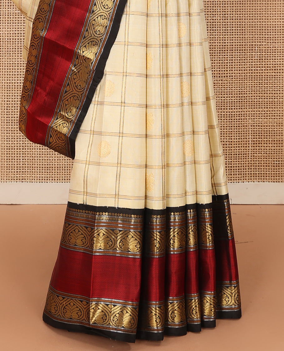 Cream iruthalai pakshi, and chakram buttas enclosed zari checked Kanchipuram silk saree, contrast rettai pettu border of salngai, muthu, and jadai nagam designs