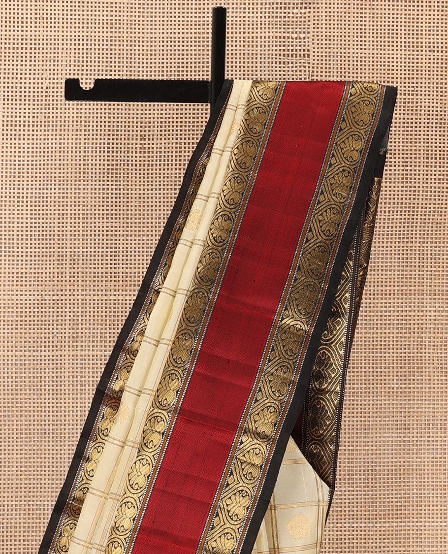 Cream iruthalai pakshi, and chakram buttas enclosed zari checked Kanchipuram silk saree, contrast rettai pettu border of salngai, muthu, and jadai nagam designs