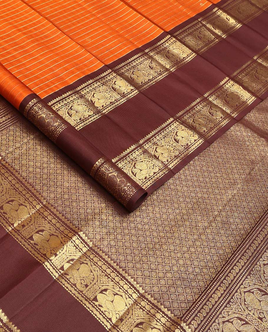 Orange zari buttas and stripes Kanchipuram silk saree, contrast rettai pettu border of thilakam mokku, muthu, manga, and mayil designs, and jaal pallu