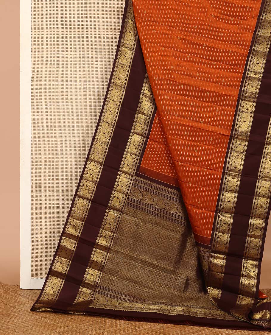 Orange zari buttas and stripes Kanchipuram silk saree, contrast rettai pettu border of thilakam mokku, muthu, manga, and mayil designs, and jaal pallu