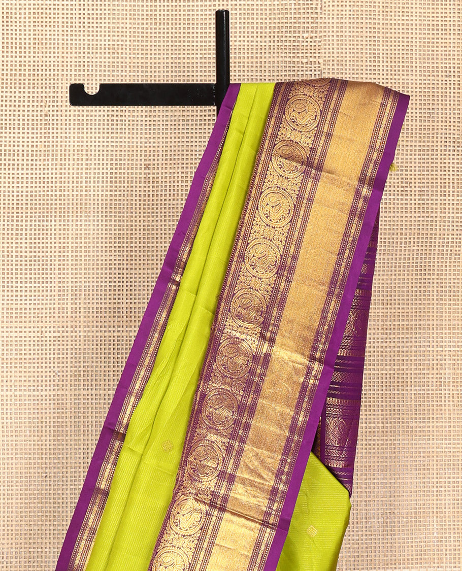 Parrot Green Vasundhara Silk Saree, Enriched with Sparse Stripes and Zari Buttas, Complemented by a Contrast Border of Thilakam, Banaras, Muthu, and Round Mayil Designs, Pallu Steeped with Traditional Designs, and Paired with a Contrast Blouse