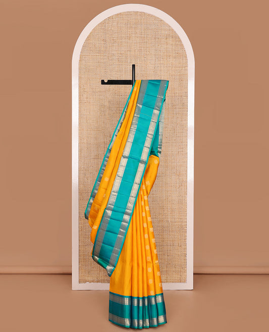 Yellow Mayuri Soft Silk Saree Subtly Sparkled with Zari Buttas All Over the Body, Complemented by a Contrast Rettai Pettu Border of Muthu and Chakram Designs, Pallu Steeped with Puli Nagam Designs, and Paired with a Contrast Blouse