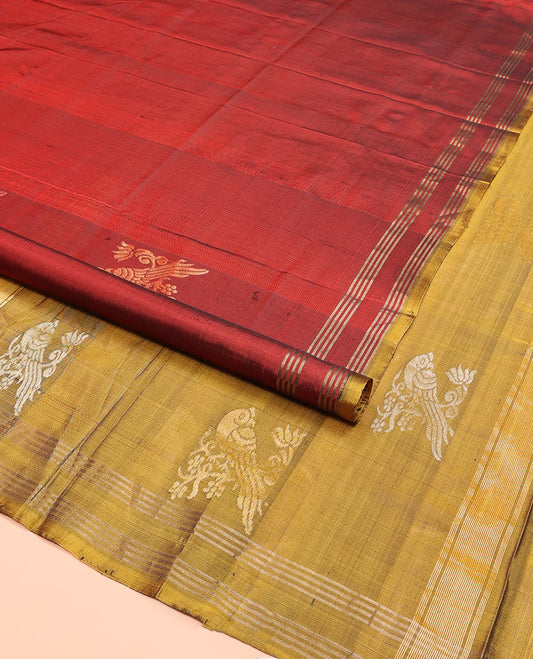 Maroon Uppada Silk Saree Embellished with Parrot Zari Buttas, Highlighted with a Contrast Piping Border, Pallu Decked Up with Zari Designs, and Paired with a Contrast Blouse