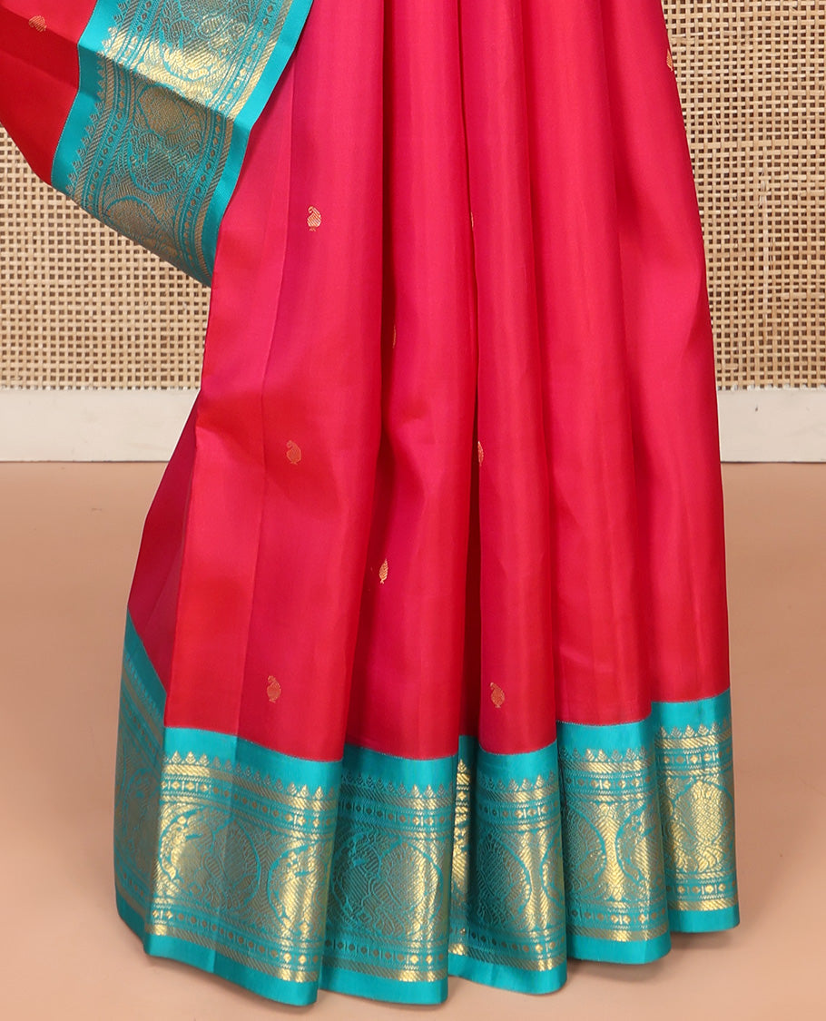 Red Vasundhara Silk Saree, Subtly Sparkled With Zari Buttas All Over Its Body, Complemented by Zari Buttas All Over Its Body, Complemented by Contrast Border of Thilakam, Banaras, and Mayil Designs Grand Jaal Pallu and Paired with a Contrast Blouse