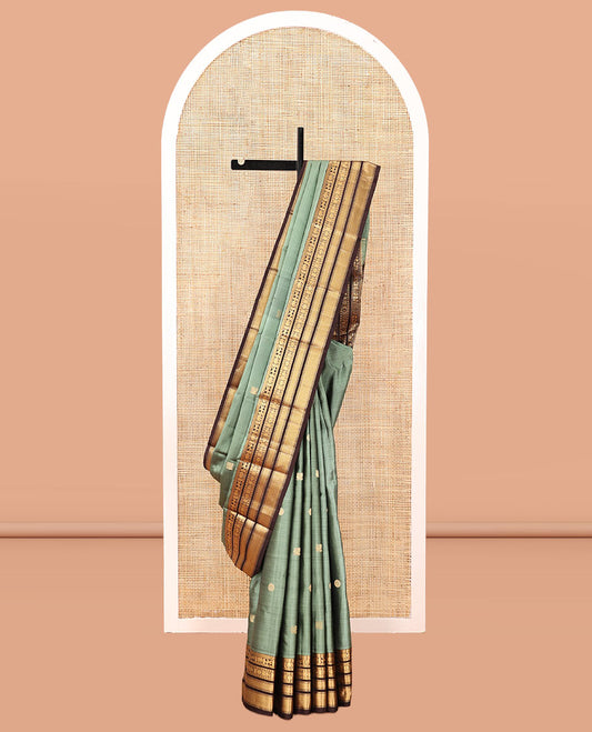 Green Vasundhara Silk Saree, Detailed with Mayil-Chakram Buttas, a Contrast Border of Thikalam, Neli, Kuthirai, Yaanai, Mayil, Chakra, and Mayil Kann, Grand Pallu, and a Contrast Blouse