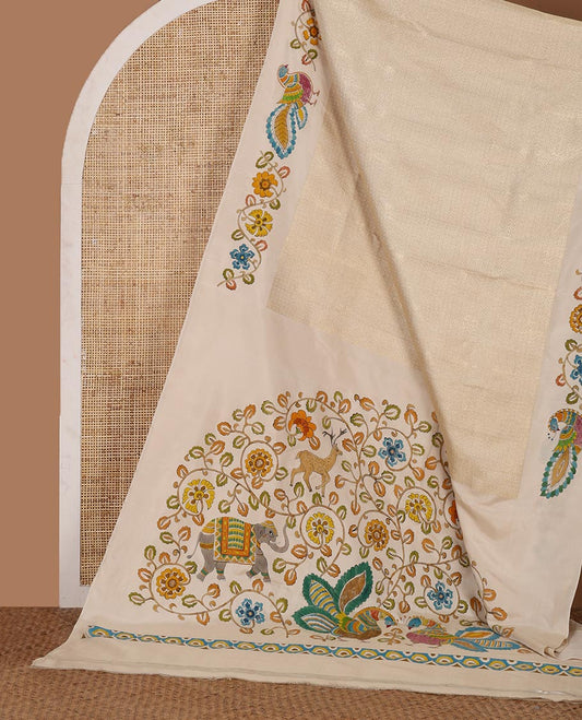 Enthralling cream kalamkari hand-painted silk saree featuring zari buttas with kalamkari floral vine, peacock, deer, & elephant motifs