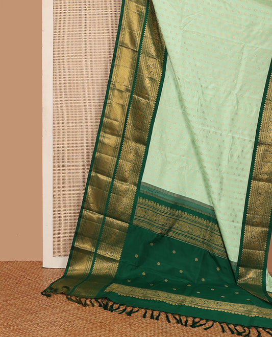 Green kamalam buttas Kanchipuram silk sareee, contrast korvai border of thilakam mokku, kathir, rudraksham, mayil, yaali and jaal design, and zari motifs pallu
