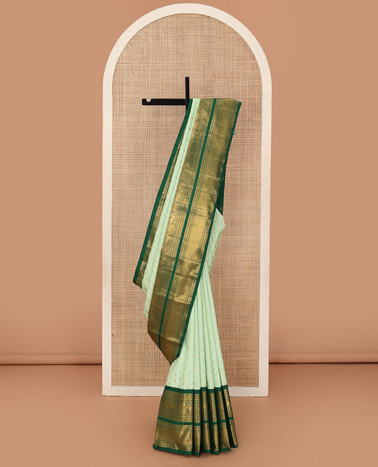 Green kamalam buttas Kanchipuram silk sareee, contrast korvai border of thilakam mokku, kathir, rudraksham, mayil, yaali and jaal design, and zari motifs pallu